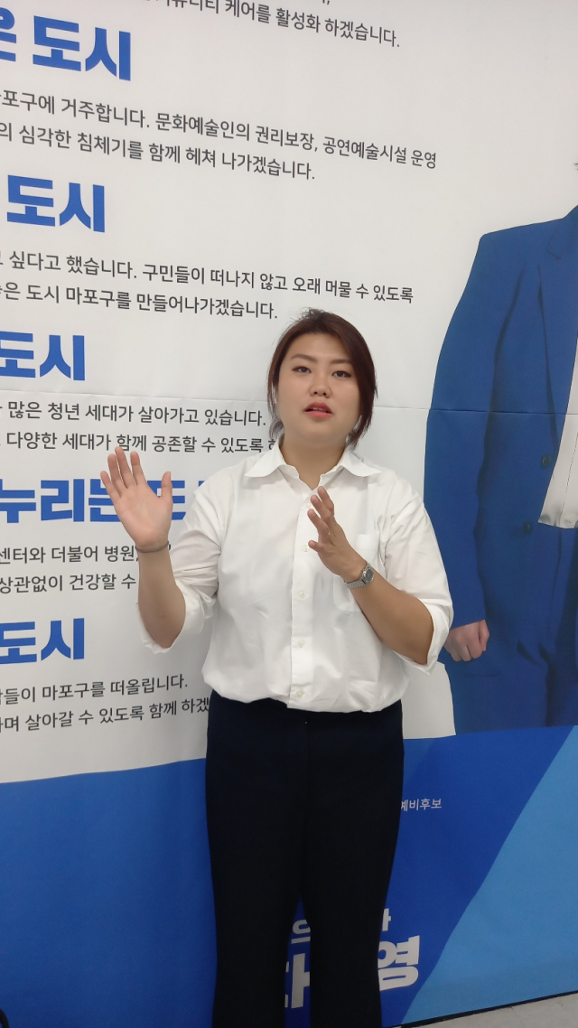 차해영 마포구 구의원 당선인이 지방선거 기간 자신이 내건 공약이 담긴 벽보 앞에서 앞으로 구정 활동 방향에 대해 설명하고 있다.