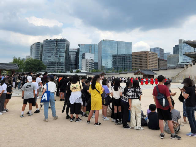 수학여행을 온 학생들이 8일 오후 서울 종로구 경복궁에서 전통 문화 행사인 수문장교대의식을 구경하고 있다. 김남명 기자