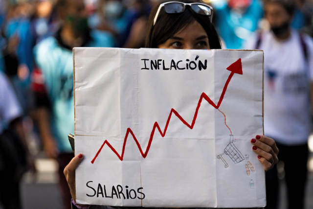 올해 4월 아르헨티나 부에노스아이레스에서 한 시민이 고물가를 비판하는 플래카드를 들고 서 있다. AFP연합뉴스