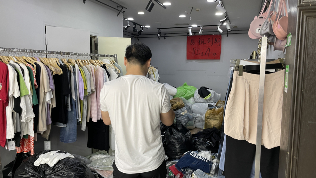 지난 17일 중국 상하이의 한 시장에서 여성복을 파는 한 상인이 폐업을 앞두고 옷을 할인 판매하고 있다. 연합뉴스