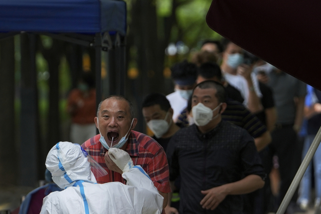 베이징 시민들이 28일 72시간 내 코로나 음성 사실을 증명하기 위한 핵산검사를 받으려 줄을 길게 서 있다. AP연합