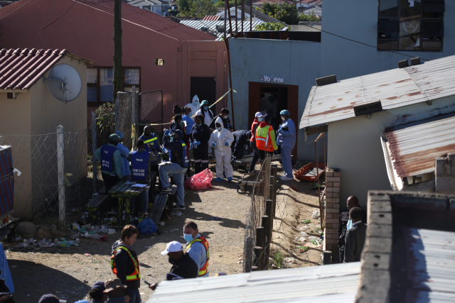 26일(현지시간) 남아프리카공화국의 한 술집에서 22명이 의문사한 가운데 당국이 시신을 수습 중인 모습. EPA 연합뉴스