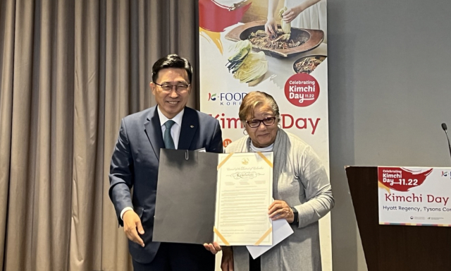 지난달 26일 김춘진 한국농수산식품유통공사(aT) 사장이 미국 버지니아주 타이슨 코너 센터에서 열린 김치 홍보행사에서 어니타 본즈 워싱턴DC 의원으로부터 ‘김치의 날’ 제정 결의안을 전달받고 있다.