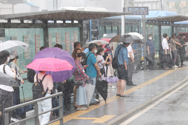 폭우로 서울 시내 도로 곳곳이 침수된 30일 오후 서울역 버스정류장에서 시민들이 버스를 기다리고 있다. 연합뉴스
