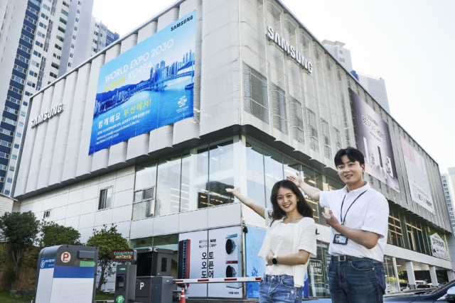 삼성전자 모델이 디지털프라자 해운대 본점 앞에서 ‘2030 부산세계박람회’ 유치를 응원하고 있다. 삼성전자는 주요 백화점 삼성 매장 등 총 23곳에서 부산세계박람회 광고 행사를 진행하고 있다. 사진 제공=삼성전자