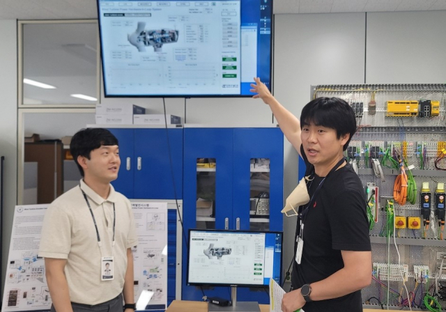 한국에너지기술연구원 김대진(오른쪽) 연구원이 대용량 풍력발전기의 신뢰성 확보를 위한 사전검증시스템에 대해 설명하고 있다. 사진제공=한국에너지기술연구원