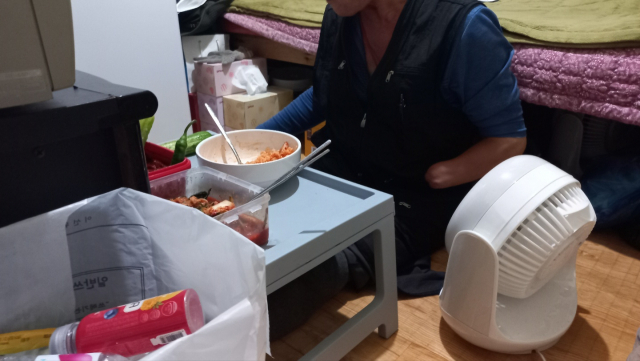 서울 용산구 동자동 쪽방촌에 거주하는 한 시민이 4일 자신의 방에서 식사를 하고 있다. 이건율 기자