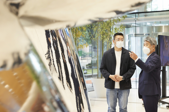 윤종원(오른쪽) IBK기업은행장과 강재원 작가가 4일 서울 을지로 기업은행 본점 로비에서 작품에 대해 이야기를 나누고 있다.