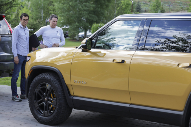 미국 아이다호주 선밸리에서 열린 선밸리 컨퍼런스에 참석한 RJ 스카린지(왼쪽) 리비안 최고경영자가 리비안의 노란색 전기 트럭을 보고 있다./AFP연합뉴스