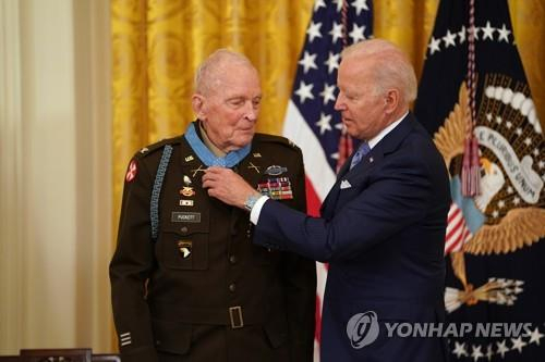 (워싱턴 EPA=연합뉴스) 조 바이든 미국 대통령이 지난 해 5월 21일(현지시간) 워싱턴DC 백악관 이스트룸에서 94세의 한국전쟁 영웅 랠프 퍼켓 주니어 예비역 대령에게 '명예훈장'(Medal of Honor)을 수여하고 있다. /연합뉴스