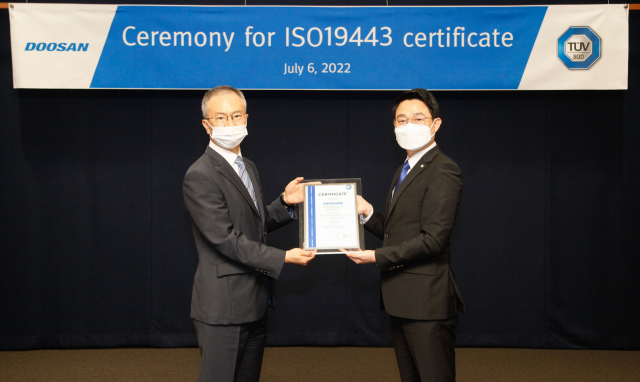 강홍규(왼쪽) 두산에너빌리티 원자력BG 강홍규 상무와 서정욱 TUV SUD Korea 대표이사가 분당두산타워에서 ISO 19443 인증서 수여식을 갖고 기념촬영을 하고 있다. 사진제공=두산에너빌리티