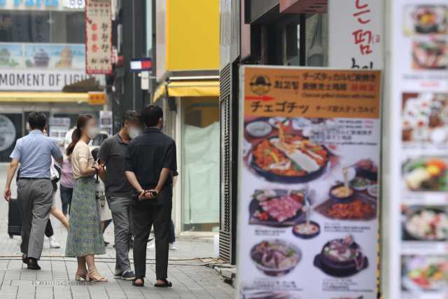 시민들이 지난 6일 점심시간 서울의 식당가에서 메뉴를 보고 있다. 연합뉴스