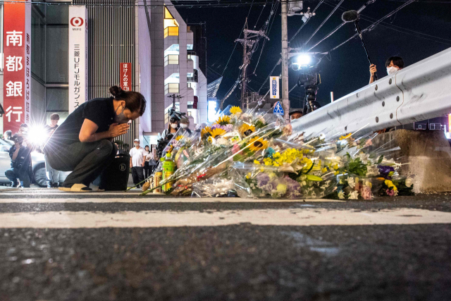 지난 8일 아베 신조 전 총리가 피격된 현장에서 그를 추모하고 있는 시민의 모습. AFP 연합뉴스