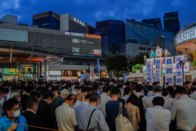 일본 자민당 관계자와 유권자들이 9일 밤 도쿄에서 참의원(상원) 선거 유세에 앞서 사망한 아베 신조 전 총리를 추모하는 묵념을 하고 있다. EPA연합뉴스
