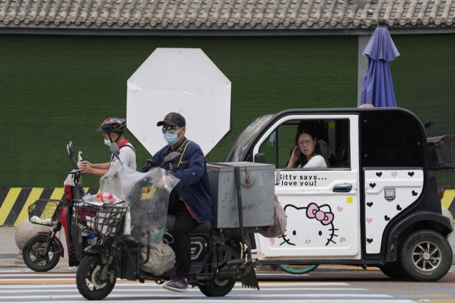 마스크를 쓴 배달원이 11일 베이징 시내를 이동하고 있다. AP연합