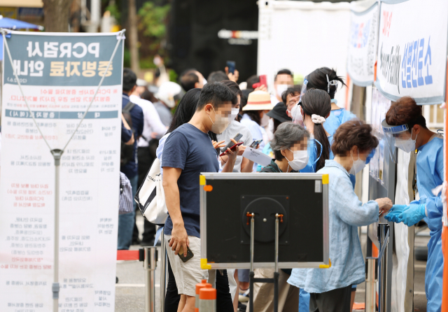 코로나19가 다시 확산하고 있는 12일 오전 서울 강남구보건소에 마련된 선별진료소를 찾은 시민들이 검사 순서를 기다리고 있다. 중앙방역대책본부에 따르면 이날 0시 기준 신규확진자는 3만 7360명으로 지난 5월 11일 4만3000여 명을 기록한 이후 62일 만에 최다치를 기록했다. 연합뉴스