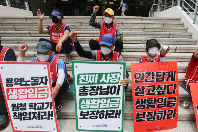 연세대학교 청소·경비노동자들이 12일 서울 서대문구 연세대학교 백양관 앞에서 열린 집회에서 구호를 외치고 있다. 연합뉴스