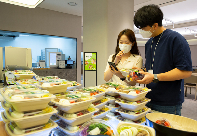 아워홈 구내식당 방문 고객들이 애플리케이션 ‘밀케어(Meal Care)’에 접속해 서비스를 이용하고 있다. 사진 제공=아워홈