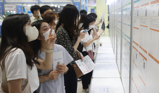 지난 5일 서울 강남구 코엑스에서 열린 2022 중견기업 일자리 박람회에서 구직자들이 채용 및 상담예약 게시판을 보고 있다. 연합뉴스