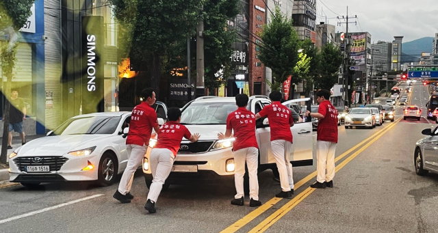 지난 7일 오후 8시께 충남 천안시 서북구 성정동의 한 도로에서 붉은색 상의를 입은 울주군청 볼링선수들이 음주운전 차량을 몸으로 막아서고 있다. 사진제공=울산 울주군