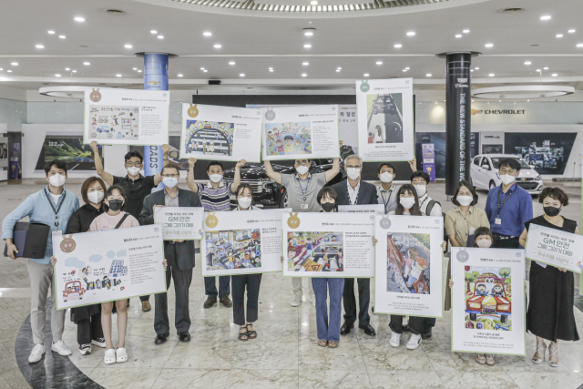 지난 12일 한국GM 부평 본사에서 개최된 그림 그리기 대회 시상식에서 GM 한국사업장 리더십과 직원 등이 그림을 들고 기념촬영을 하고 있다. 사진 제공=한국GM