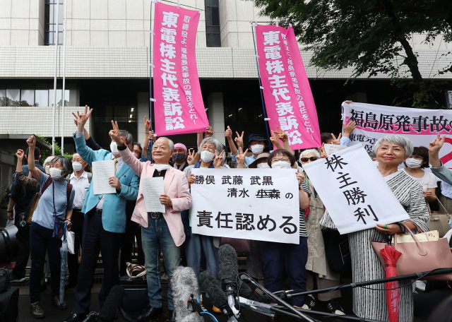 일본 도쿄지방재판소가 13일 2011년 발생한 후쿠시마 제1 원전 사고와 관련해 원전 운영사인 도쿄전력의 당시 경영진에 배상 책임이 있다고 판결하자 소송을 제기한 도쿄전력 주주들이 법원 앞에서 승소를 축하하고 있다. AFP연합뉴스