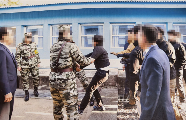 통일부는 지난 2019년 11월 판문점에서 탈북어민 2명을 북한으로 송환하던 당시 촬영한 사진을 12일 공개했다. 사진은 탈북어민이 몸부림치며 북송을 거부하는 모습./사진=통일부