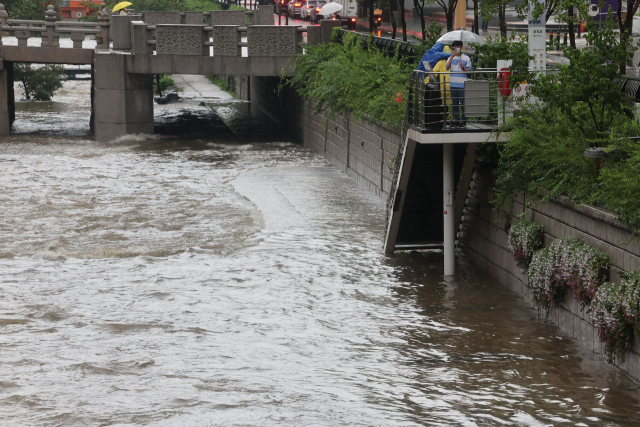 서울에 많은 비가 내리는 13일 오후 서울 청계천 산책로에 물이 넘치고 있다. 연합뉴스