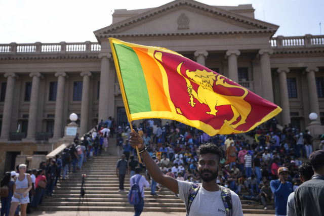 13일(현지 시간) 고타바야 라자팍사 스리랑카 대통령 집무실 앞에서 시위대가 깃발을 흔들고 있다. AP연합뉴스
