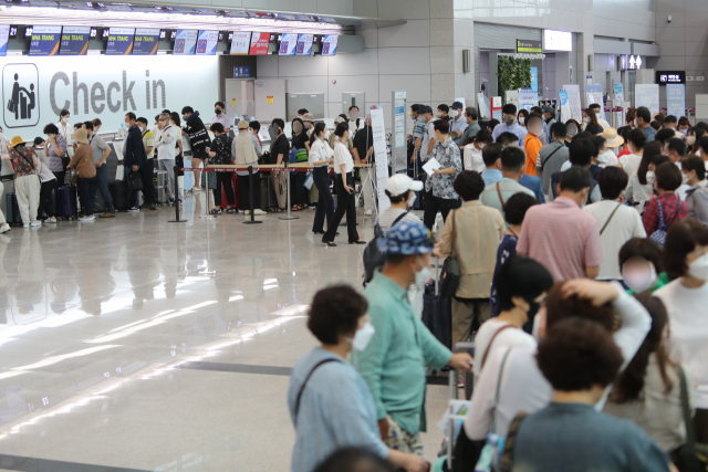 14일 전남 무안군 무안국제공항 국제선 출국장에서 탑승객들이 체크인을 하고 있다. 코로나19 여파로 운항이 중단된 지 2년 4개월 만에 무안공항은 이날 무안-베트남 나트랑(냐짱) 노선을 시작으로 국제선 운항을 다시 시작한다. 연합뉴스