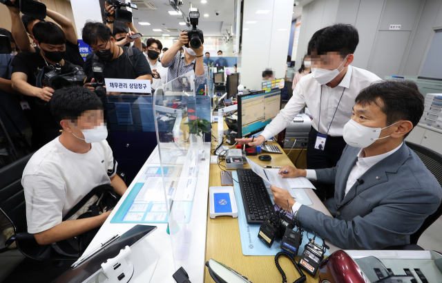 금융권 취약차주 지원 프로그램 관련 현장 방문에 나선 이복현(오른쪽) 금융감독원장이 14일 오후 서울 중구 신한은행 남대문지점에서 은행 직원의 도움을 받아 고객 채무 관리 상담을 하고 있다. 연합뉴스