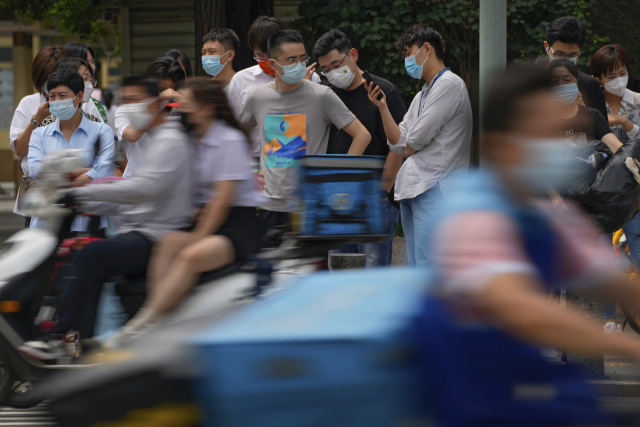 6일 중국 베이징의 한 횡단보도 앞에서 시민들이 마스크를 착용한 채 신호를 기다리고 있다. AP연합뉴스