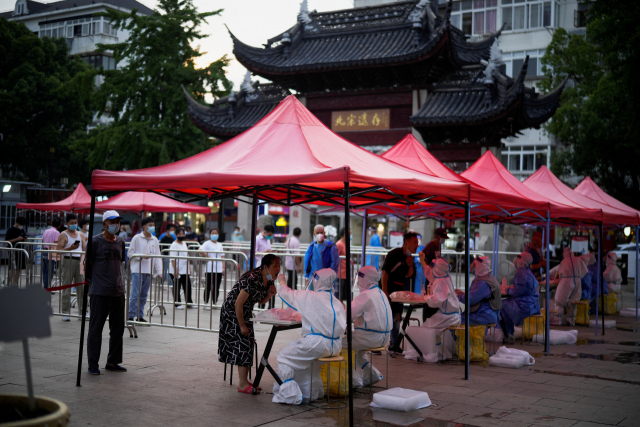 12일 중국 상하이 시내 진료소에서 주민들이 코로나19 검사를 받고 있다. 연합뉴스