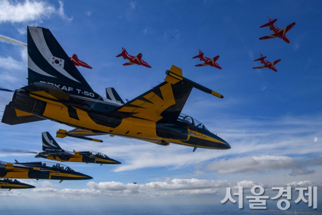 대한민국 공군 특수비행팀 블랙이글스가 지난 17일 리아트 에어쇼에서 국산 고등훈련기 T-50을 타고 영국 공군의 특수비행팀 레드 애로우즈와 우정비행을 선보이고 있다. 사진제공 공군