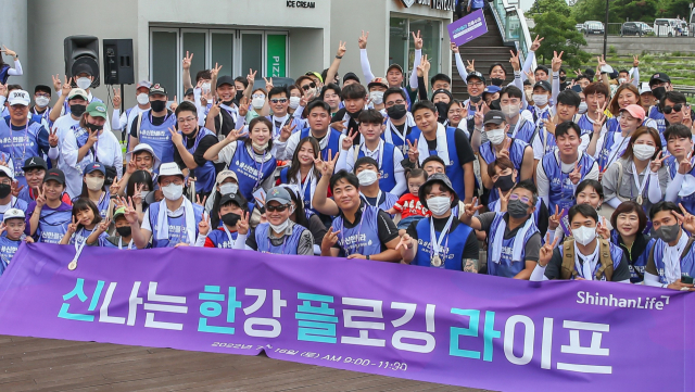 지난 16일 여의도 한강공원에서 진행된 플로깅 캠페인에 참석한 성대규(맨 앞줄 일곱번째) 신한라이프 사장이 참석자들과 함께 기념촬영을 하고 있다. 사진 제공=신한라이프