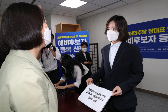 박지현 더불어민주당 전 공동비상대책위원장이 18일 국회 의원회관에 마련된 민주당 중앙당 선관위 접수처에 당 대표 예비 경선 후보자 등록을 위해 서류를 관계자에게 내밀고 있다. 접수처 관계자는 