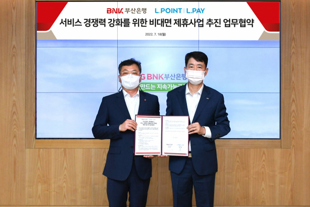 정영준(오른쪽부터) BNK부산은행 고객지원그룹장, 표수형 롯데멤버스 영업부문장이 18일 오전 부산은행 본점에서 ‘서비스 경쟁력 강화를 위한 비대면 제휴사업 추진 업무 협약’을 체결하고 있다. 사진 제공=BNK부산은행