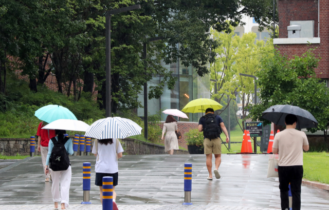 18일 오전 광주 북구 전남대 교정에서 학생들이 우산 쓰고 등교하고 있다. 연합뉴스