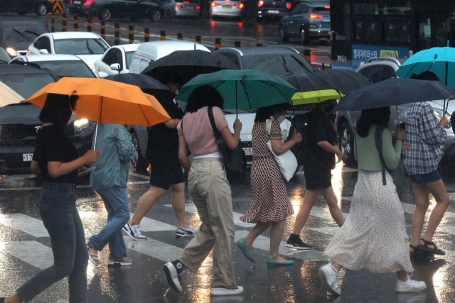 서울 서대문구 연세대학교 앞 횡단보도에서 학생 등 시민들이 우산을 쓴 채 걸어가고 있다. 연합뉴스