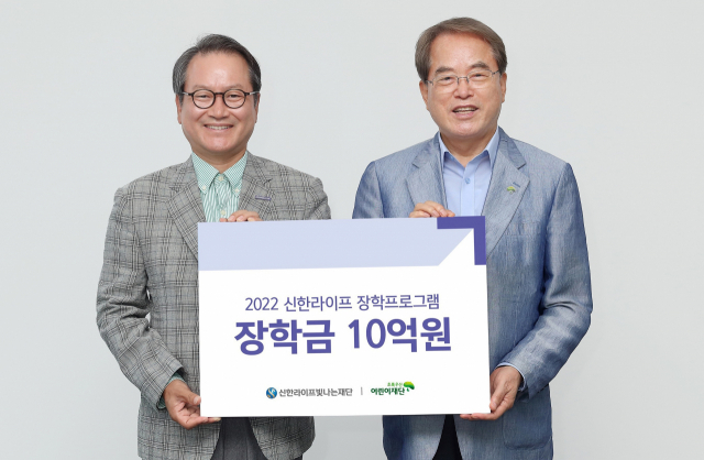 성대규(왼쪽) 신한라이프빛나는재단 이사장이 서울 중구 신한L타워에서 초록우산 어린이재단 이제훈 회장에게 장학금 10억원의 기부금을 전달하고 있다. 사진 제공=신한라이프