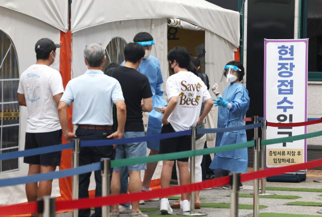 코로나19 신규 확진자 수가 6만 8632명을 기록한 22일 오전 서울 강남구보건소 코로나19 선별진료소에서 시민들이 검사를 위해 줄을 서 있다. 연합뉴스