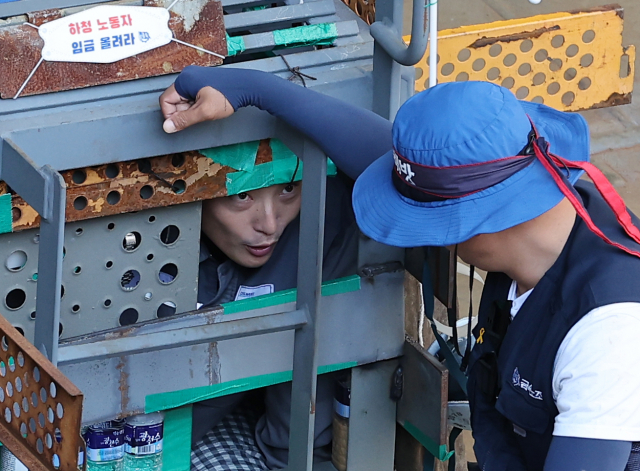 대우조선해양 하청노조 파업 51일째인 22일 오전 경남 거제시 대우조선해양 옥포조선소 1독의 가로, 세로, 높이 각 1ｍ 철 구조물에서 31일째 농성을 이어가고 있는 유최안 금속노조 거제통영고성 조선하청지회 부지회장이 관계자와 이야기를 나누고 있다. 연합뉴스