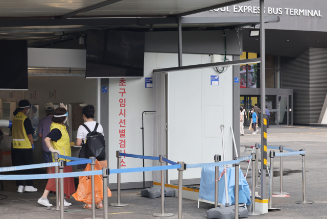 코로나19 신규 확진자가 6만 8632명 발생한 22일 오후 운영을 재개한 서울 서초구 서울고속버스터미널 코로나19 임시 선별검사소에서 시민들이 검사를 위해 줄 서 있다. 연합뉴스