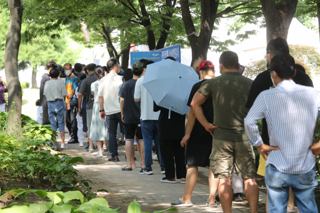 26일 대전시청 남문광장에 마련된 임시 선별검사소가 운영을 시작하는 오전 10시 이전부터 시민들이 PCR 검사를 받기 위해 줄을 서서 기다리고 있다. 연합뉴스