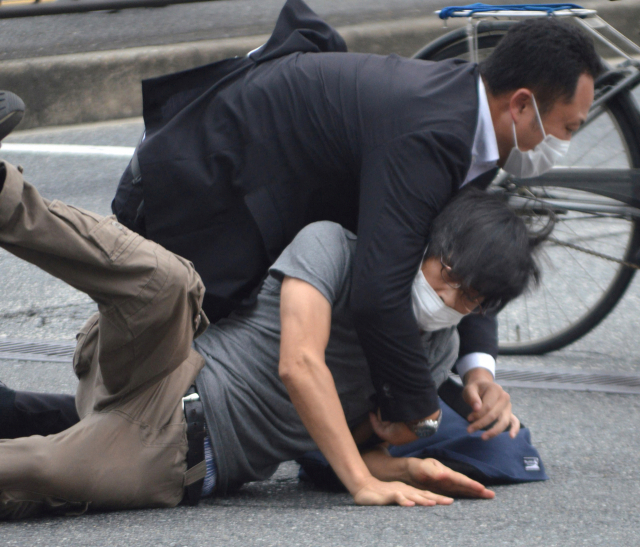 지난 8일 일본 나라현 나라시 야마토사이다이지역 앞에서 참의원 선거 유세활동을 하던 아베 신조 전 일본 총리(67)를 총기로 저격한 용의자 야마가미 데쓰야가 범행 직후 제압당하고 있다. 로이터연합뉴스