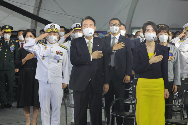 윤석열 대통령과 김건희 여사가 28일 오전 울산시 현대중공업에서 열린 차세대 이지스구축함 정조대왕함 진수식에서 국기에 경례하고 있다. 연합뉴스