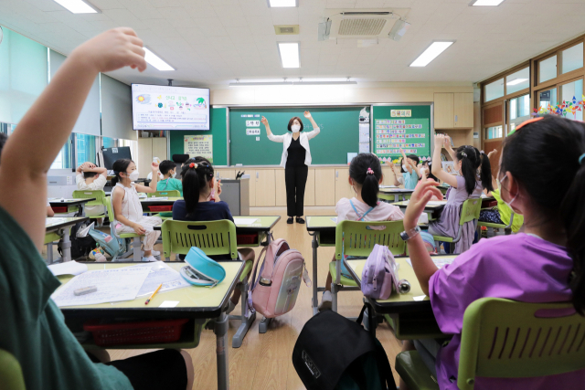 학생들이 15일 오후 서울 중구 청구초등학교에서 선생님과 인사를 나누고 있다. 연합뉴스