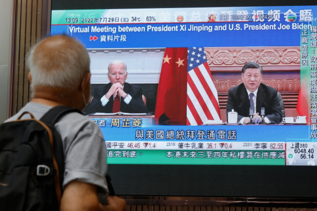 29일 홍콩의 한 쇼핑몰에서 한 시민이 시진핑 중국 국가주석과 조 바이든 미국 대통령의 전화 회담 뉴스를 시청하고 있다. / 로이터연합뉴스