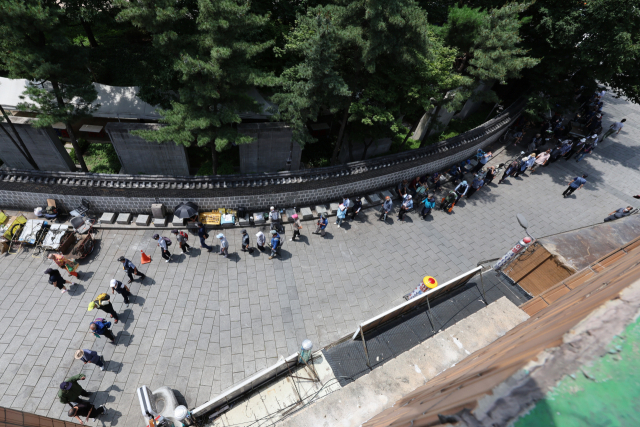 점심식사를 하려는 노인들이 서울 종로구 탑골공원 원각사 노인 무료급식소 앞에 줄을 지어 서 있다. 연합뉴스