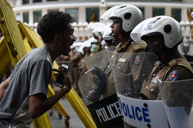 22일(현지 시간) 스리랑카 콜롬보에서 라닐 위크레마싱헤 신임 대통령에게 반대하는 시위에 나선 한 시민이 도로를 통제하는 경찰에게 소리를 지르고 있다. 5월 디폴트(채무 불이행)를 선언한 스리랑카에서는 정정 불안이 계속되고 있다. AFP연합뉴스